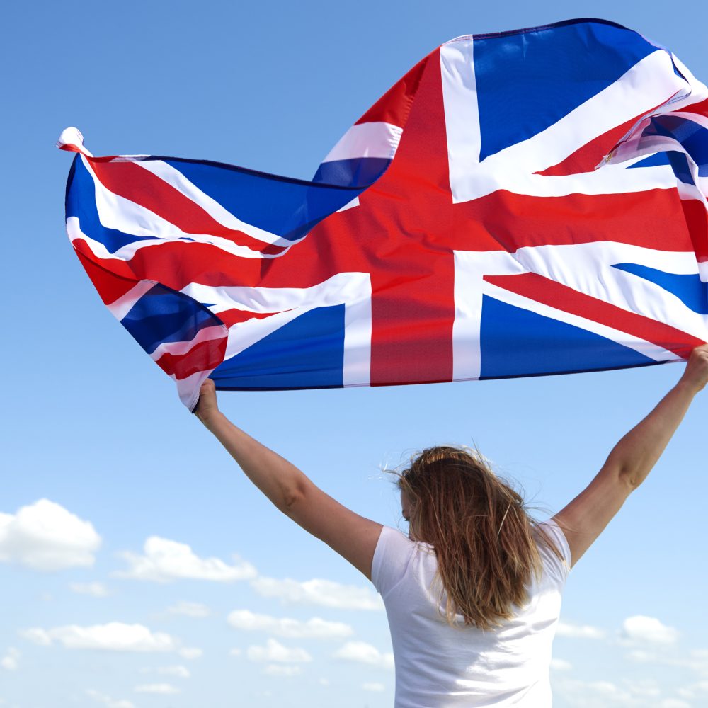 Rear view of young woman waving the British flag